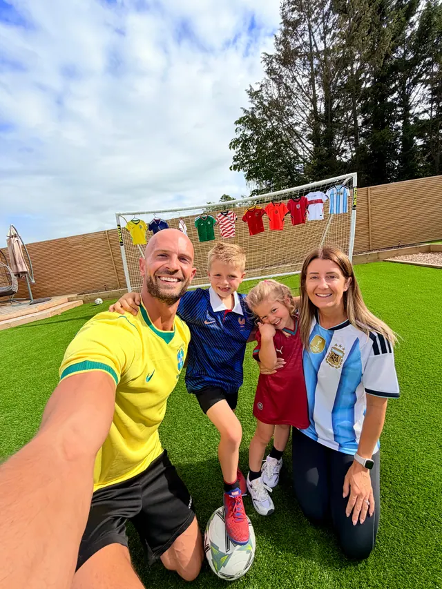 Daniel and the family on their garden pitch, all in football shirts